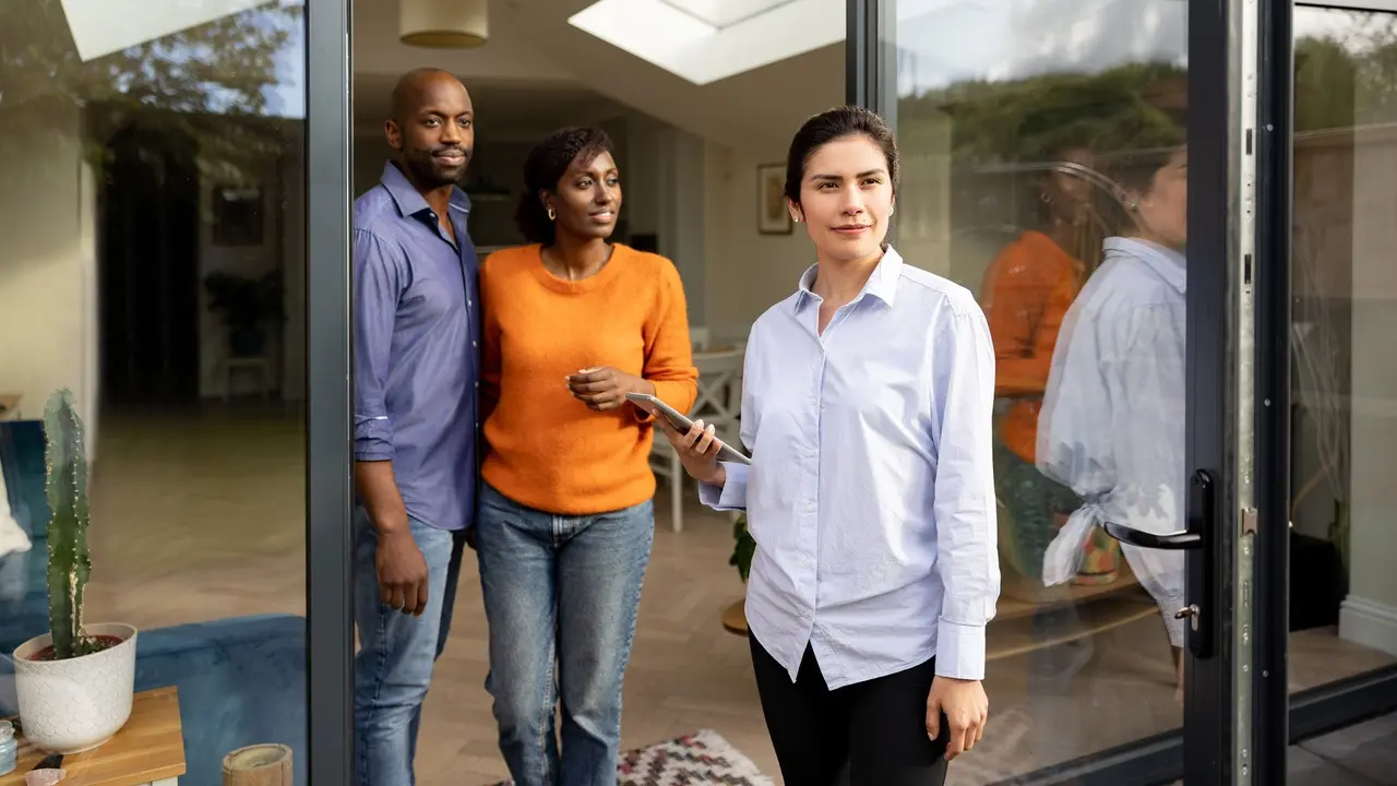 Real estate agent showing a house to a black couple stock photo