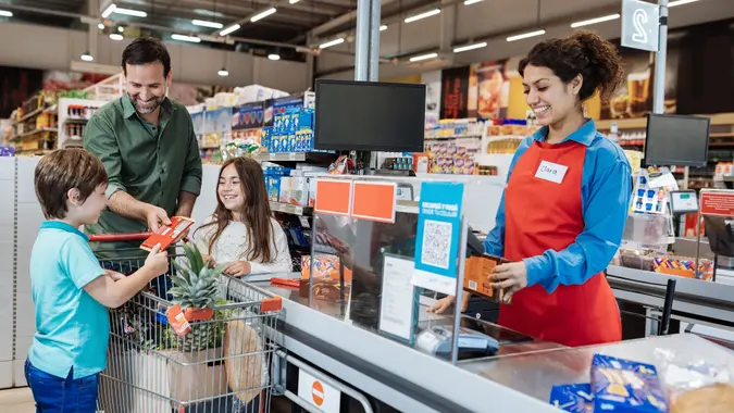 Family buying in supermarket, father paying at the checkout stock photo