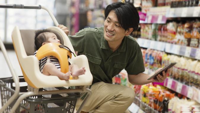 Father grocery shopping in the supermarket stock photo