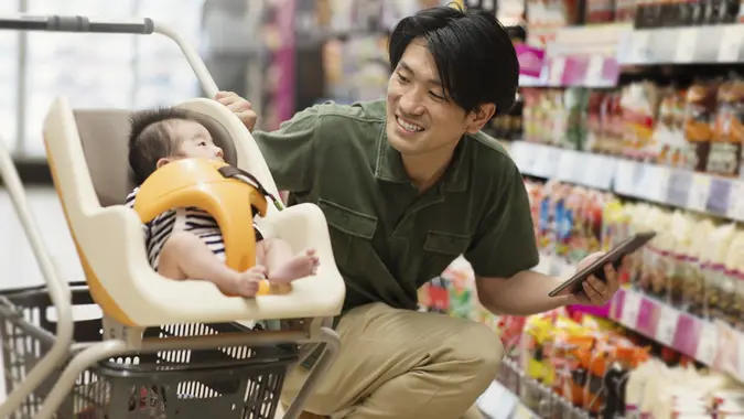 Father grocery shopping at the supermarket stock photo