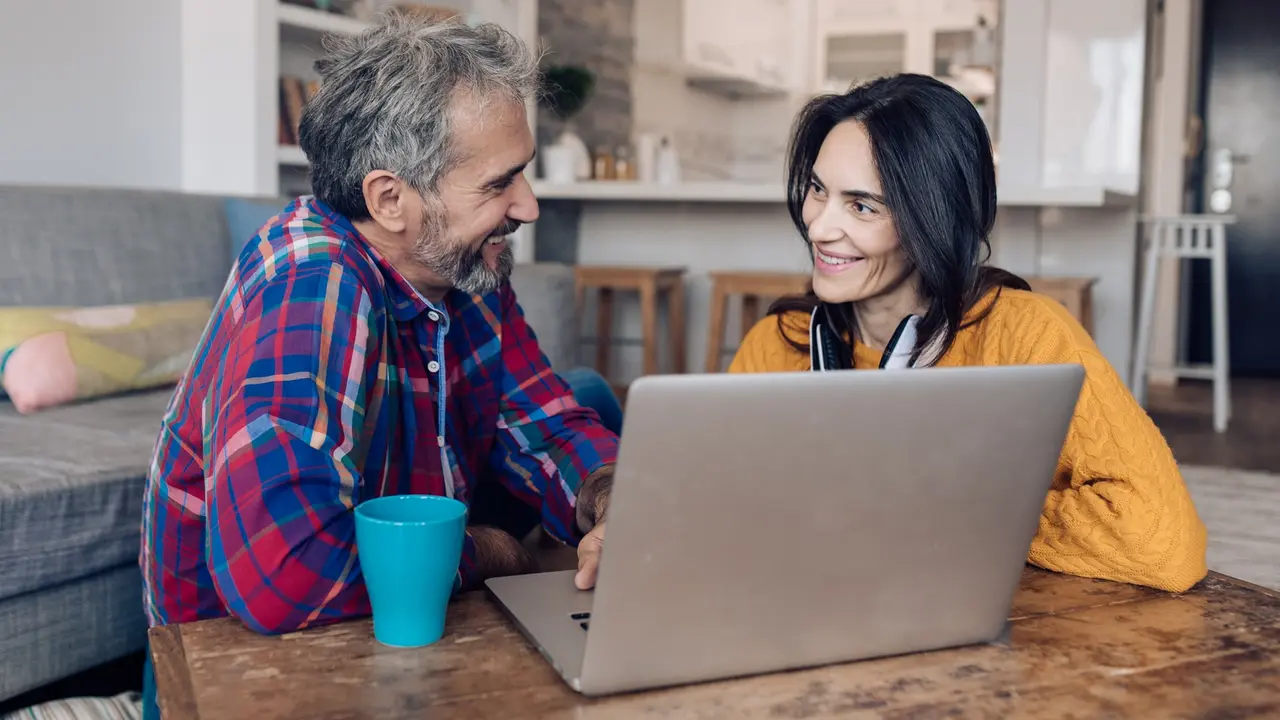 Mature couple working on the computer at their living room stock photo