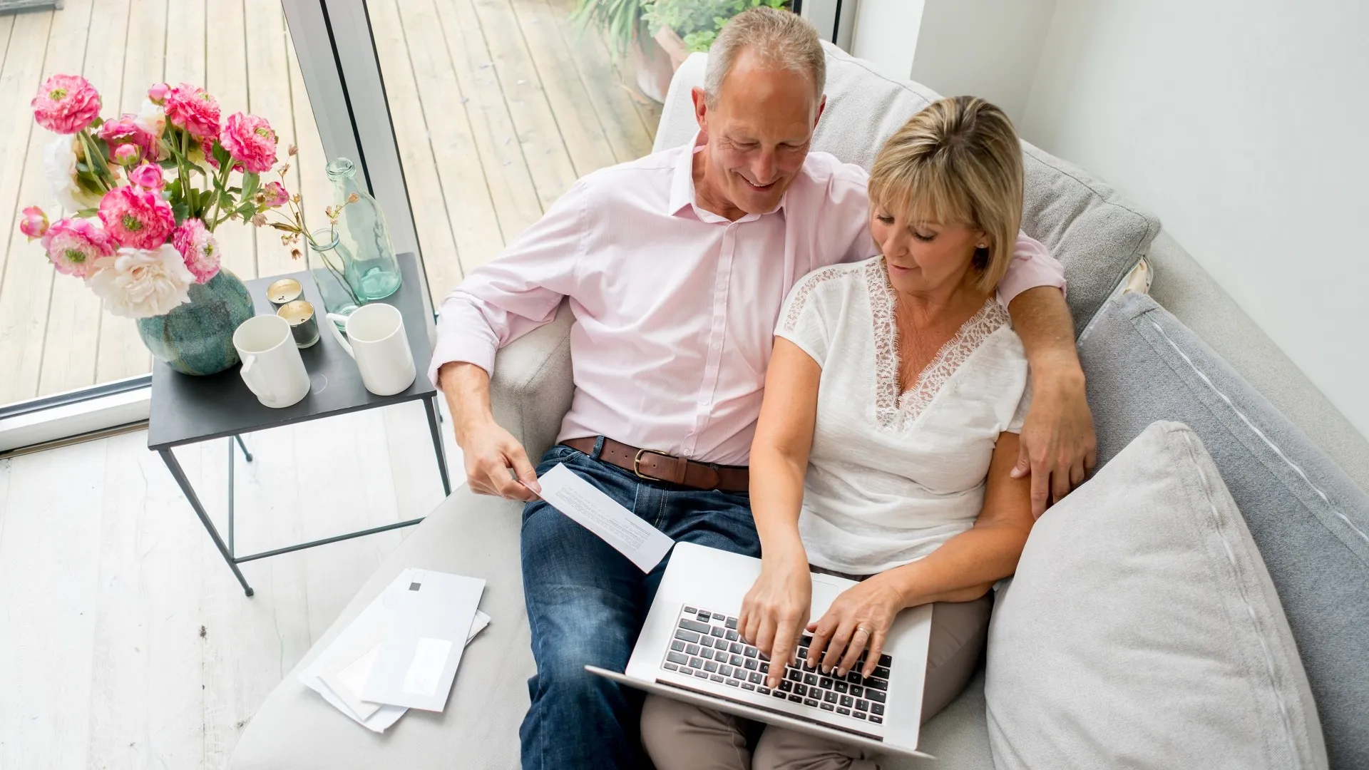 Senior couple paying bills online at home stock photo