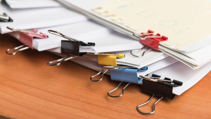Paper business documents with color clips Paper business documents of unfinished stacked on office desk archive,in archive analyzing the market.