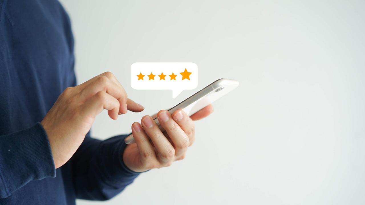 close up on customer man hand pressing on smartphone screen with  five star rating feedback icon and press level good rank for giving best score point to review the service , technology business concept.