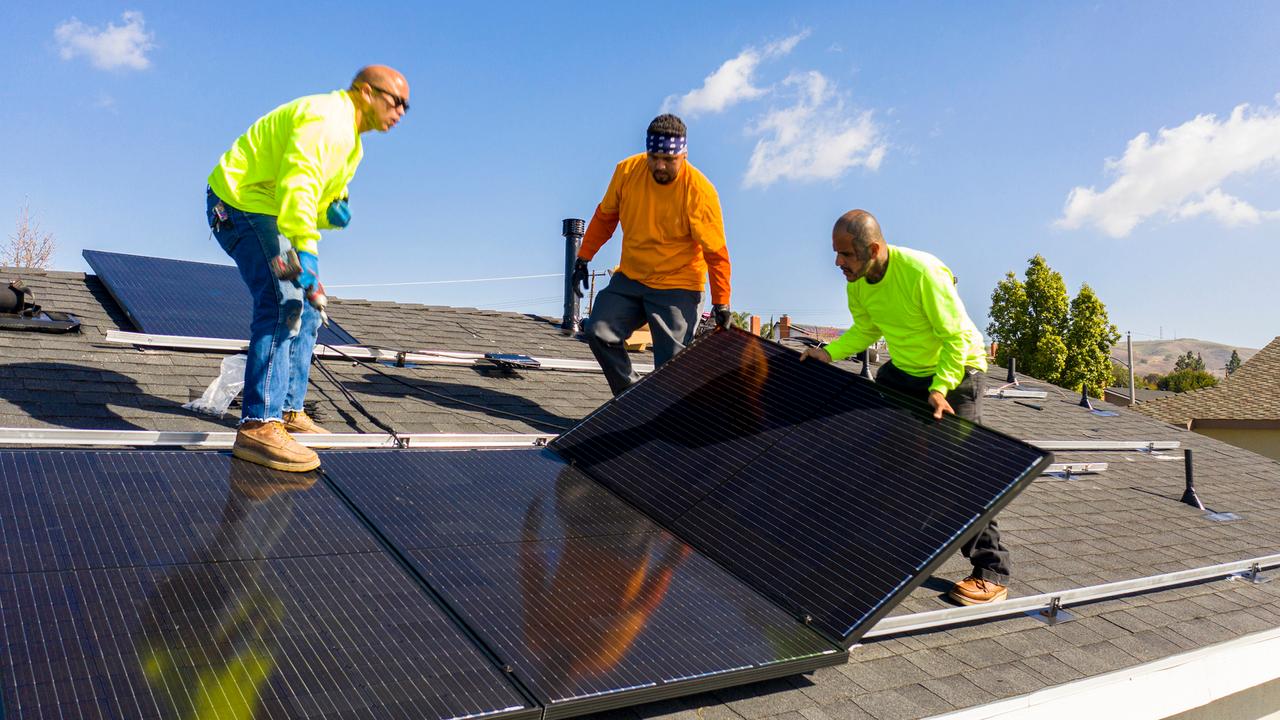 A team of workers installing solar panels on a home in Southern California.