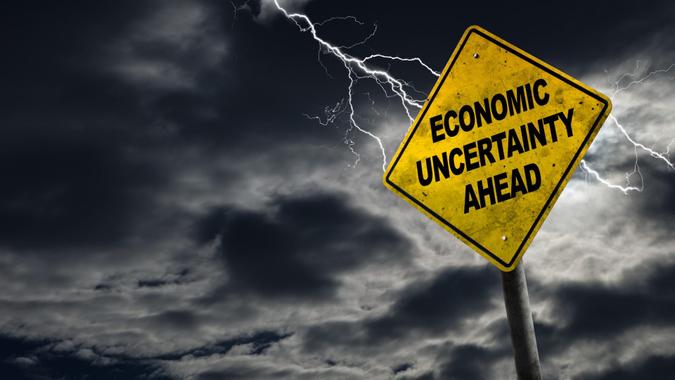 Economic Uncertainty sign against a stormy background with lightning and copy space.
