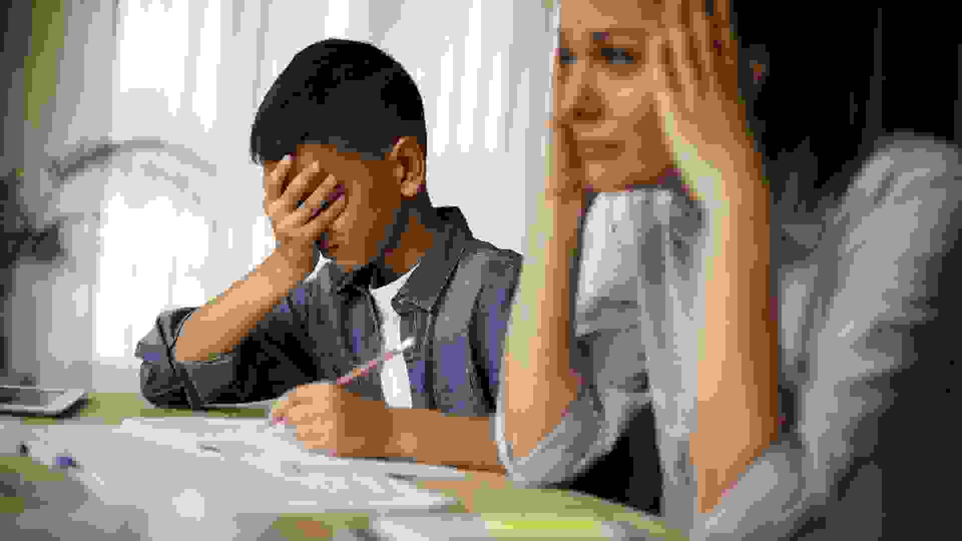 Teenage boy having problems in finishing homework stock photo