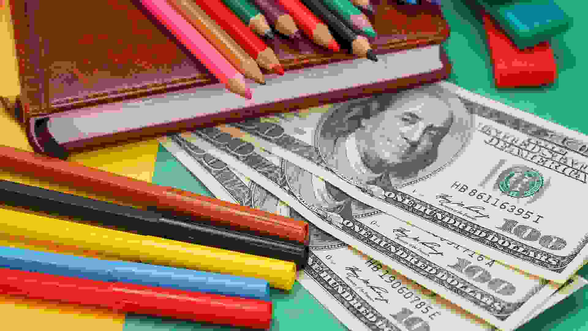 Pens, colored pencils, plasticine, book, hundred dollar bills stock photo