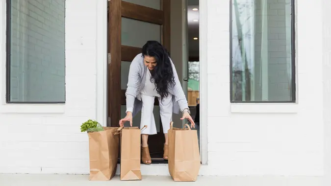Mature woman steps out to pick up e-commerce grocery order stock photo