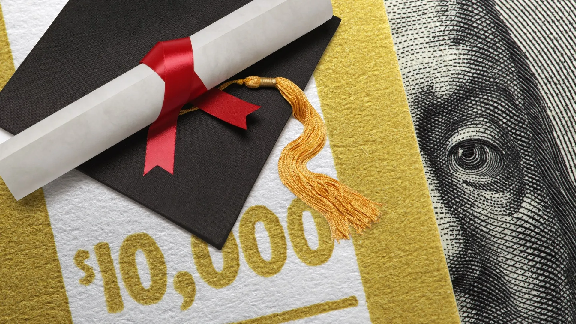 Graduation Cap And Diploma On $10,000 stock photo