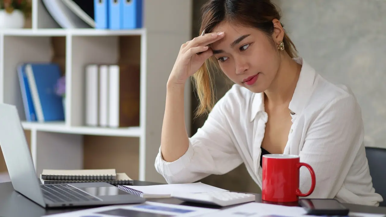 Serious businesswoman in the office is tired from overwork and headaches from stress. stock photo