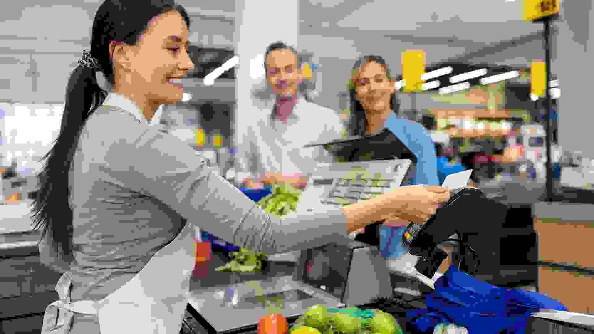 Couple shopping at the supermarket and paying by card to the cashier stock photo