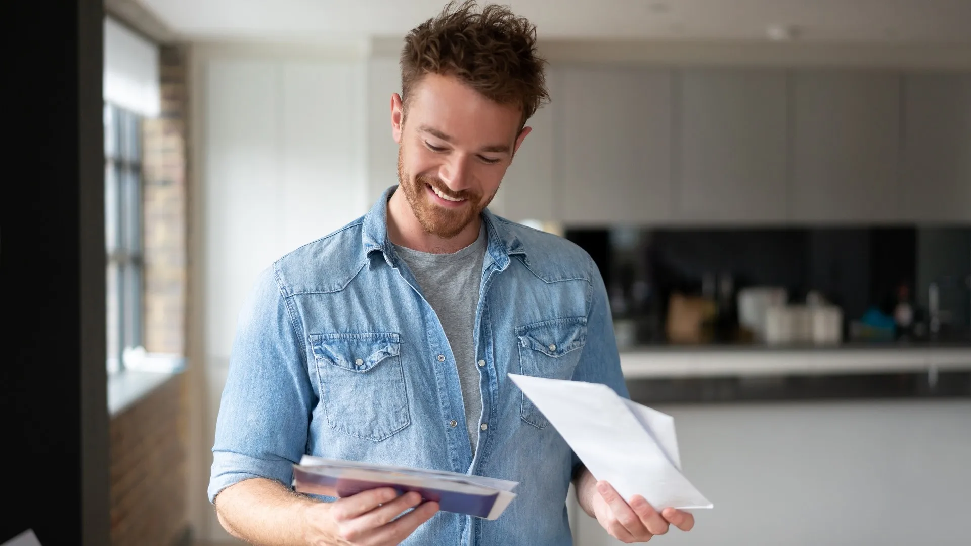 Happy man at home checking the mail stock photo