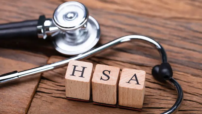 HSA Health Savings Account Wooden Blocks Near Stethoscope On Wooden Table.