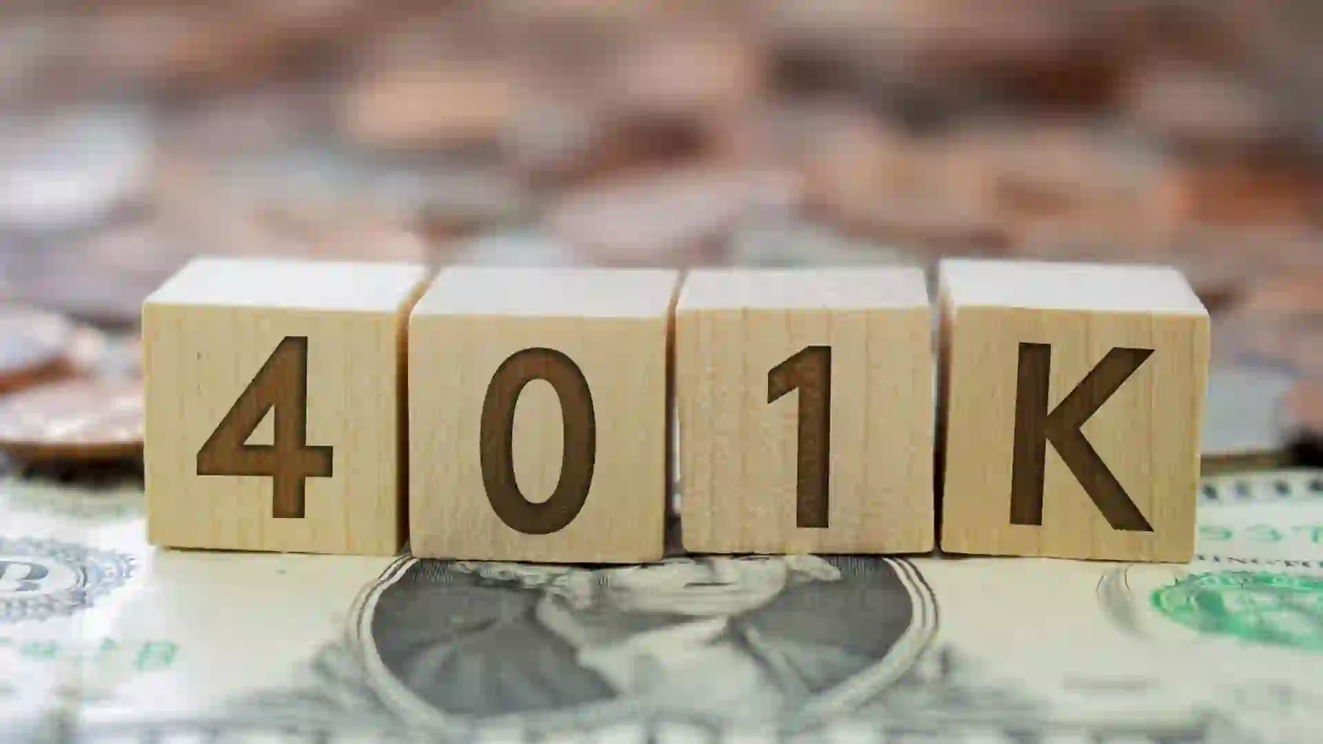 Wooden block with the number 401K with some money around.