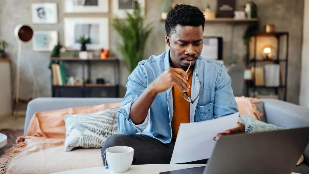 Shot of a young man going over his finances at home.