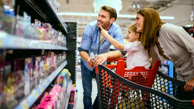 Family with one child shopping together in toy store.