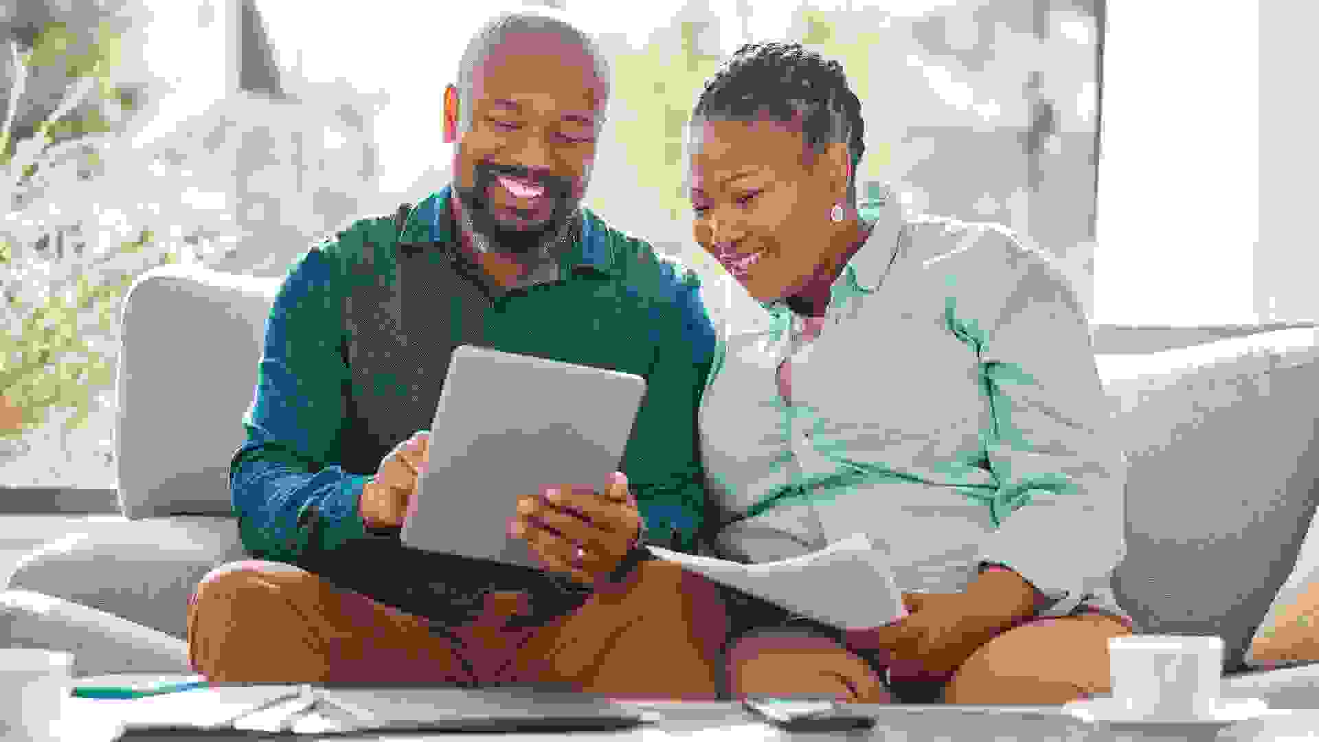 Shot of a mature couple looking through their bills while using a digital tablet stock photo