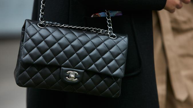Woman with black Chanel leather bag with silver chain stock photo