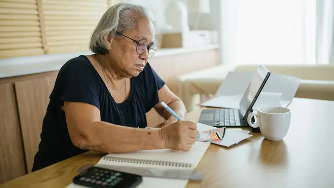 Asian woman calculating expenses. stock photo
