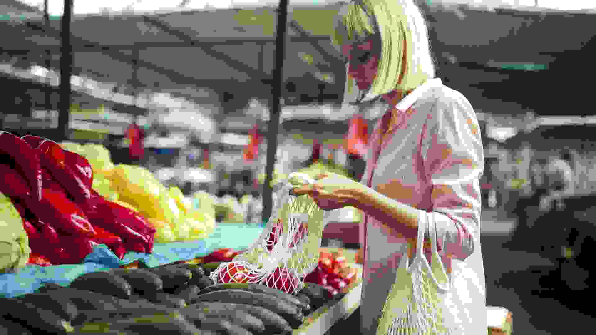 A beautiful woman is shopping for organic food at the market. stock photo