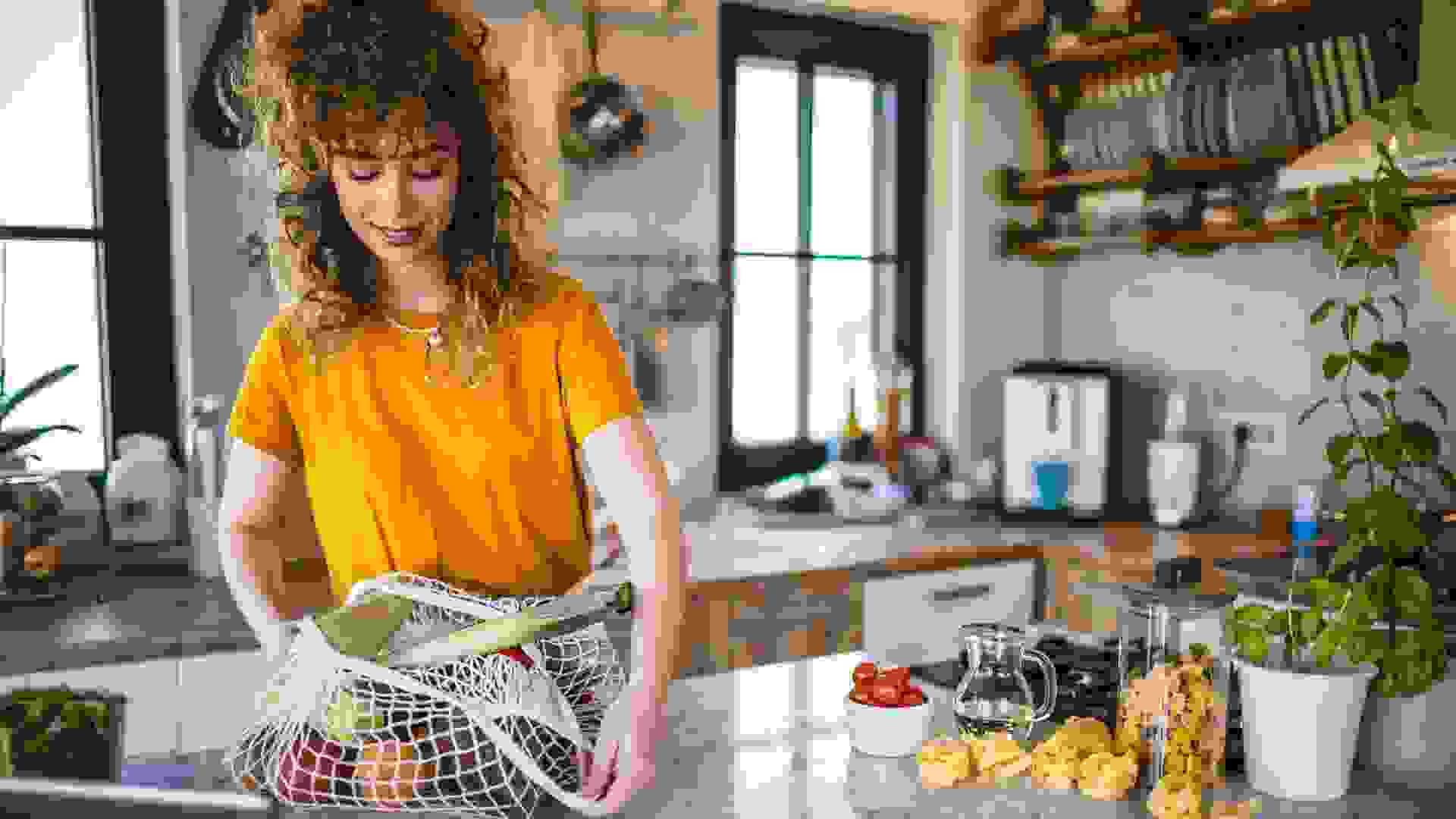 Woman coming home with shopping bag full of fresh food stock photo