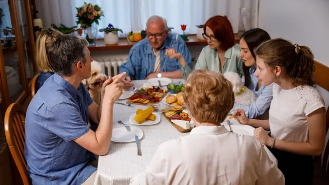 Multigeneration family having dinner and chatting casually stock photo