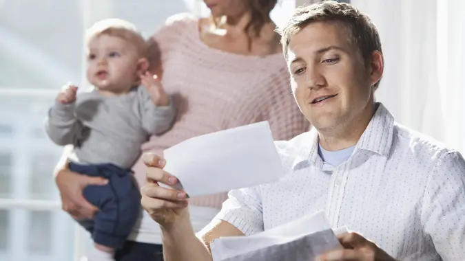 Mother and baby, father paying bills stock photo