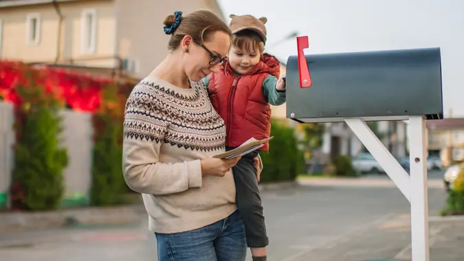 Family sending or receiving mail with mailbox near house stock photo