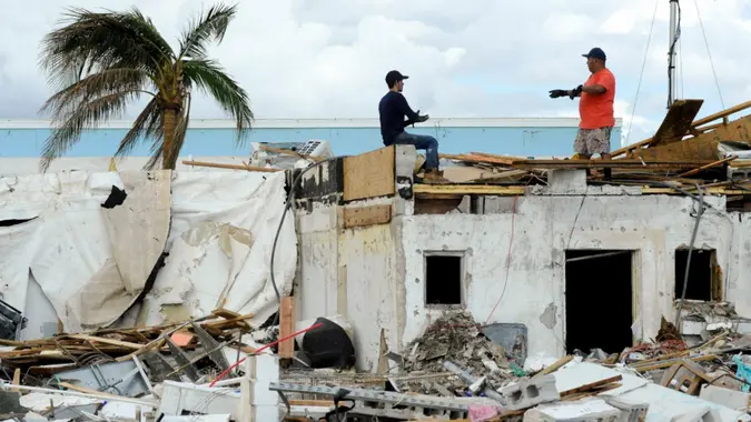 Mandatory Credit: Photo by Jay Reeves/AP/Shutterstock (13452477b)Workers talk atop a building that was heavily damaged by Hurricane Ian at Fort Myers Beach, Fla.