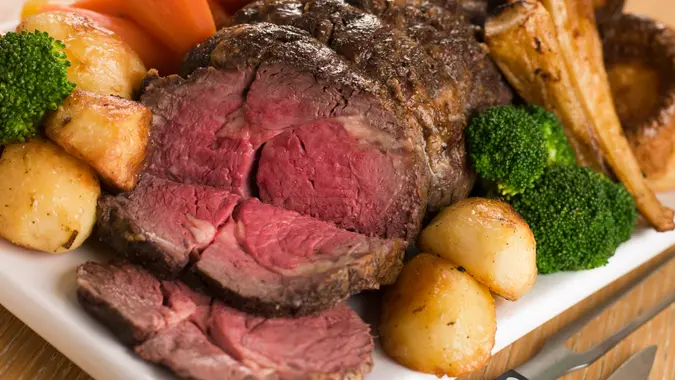 Roast Rib eye of British Beef with all the Trimmings on White Dish.