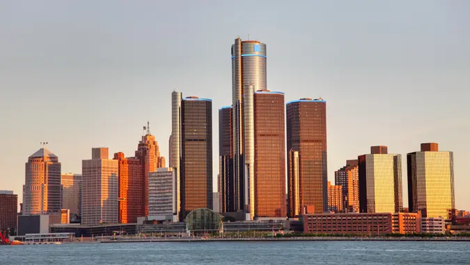 Detroit city skyline along the Detroit River at dusk.