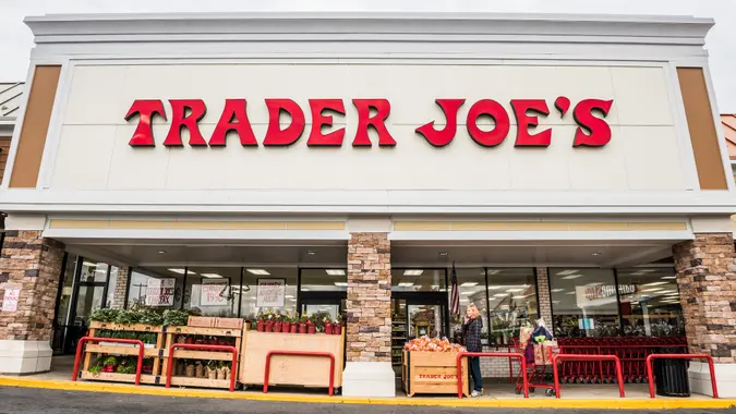 Fairfax, USA - November 25, 2016: Trader Joes grocery store facade with sign and items on display and people walking.
