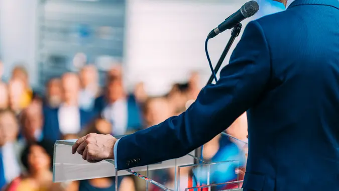 Politician during election campaign, speaking to the crowd from stage.