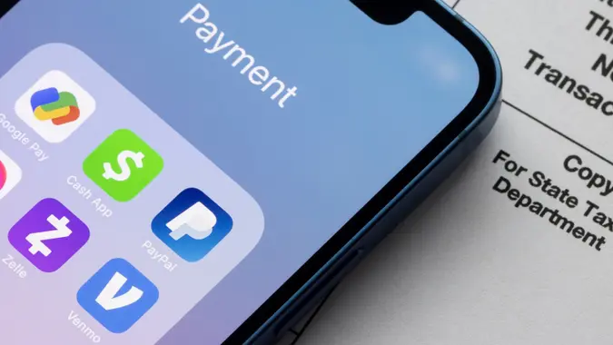 Portland, OR, USA - Jan 5, 2022: Payment apps like PayPal and Venmo are seen on an iPhone on top of Form 1099-k.