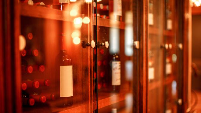 Wine cabinet with glass doors with wine bottles stacked inside Wine cubby with glass doors with wine bottles stacked within in a wine cellar.