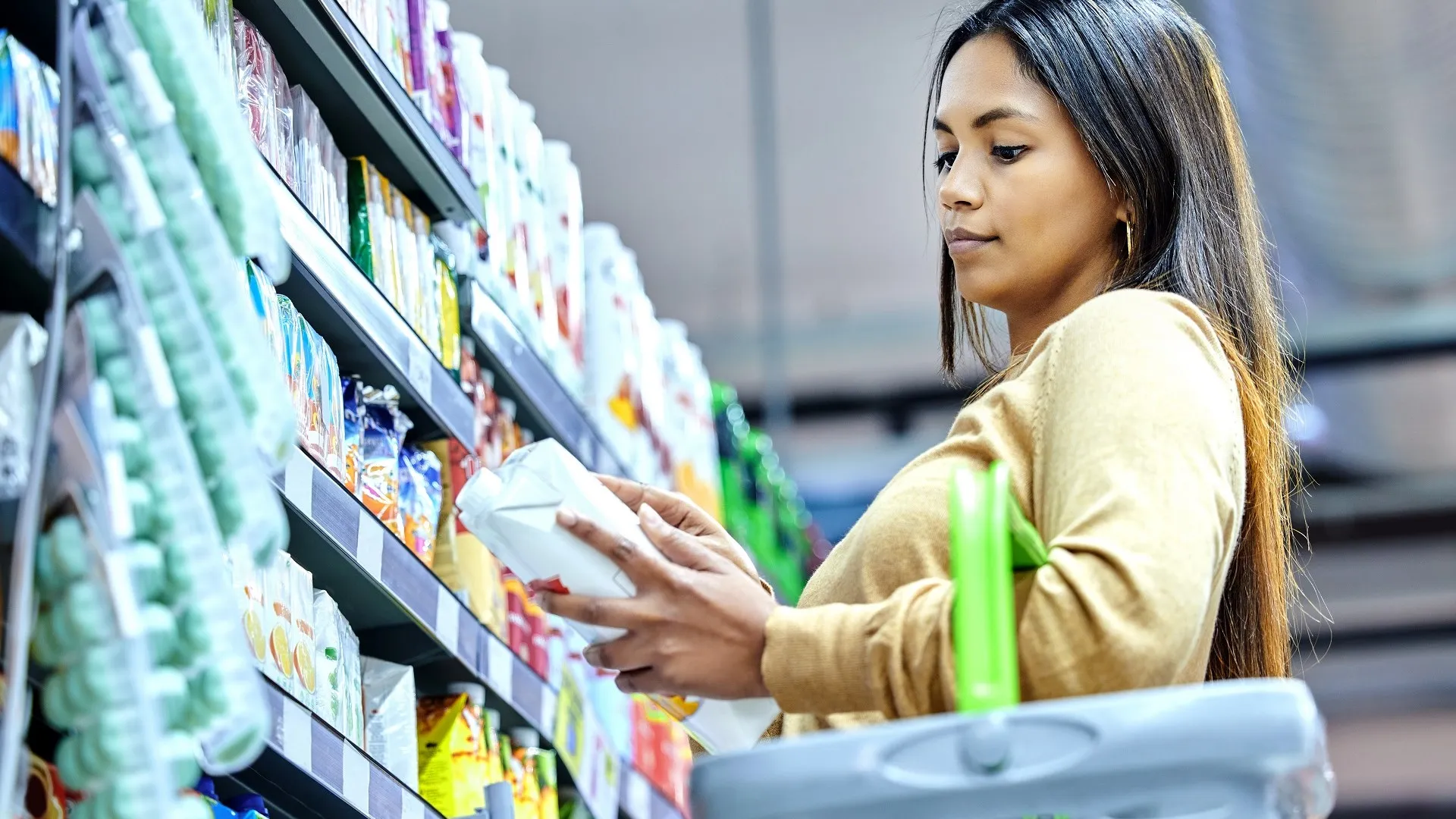 Shot of a young woman shopping at a grocery store stock photo