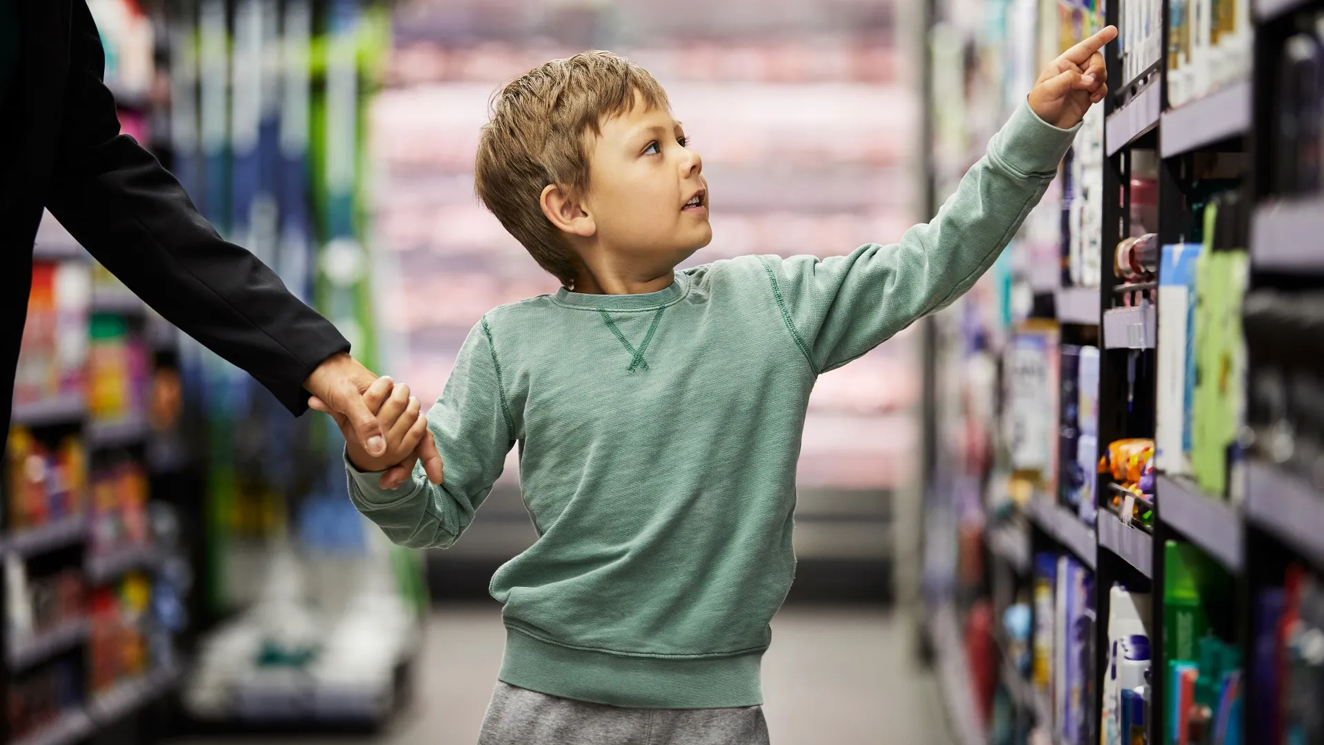 一个小男孩在超市的货架上拍了一张照片