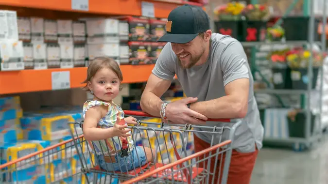 Dad and toddler daughter grocery shopping stock photo