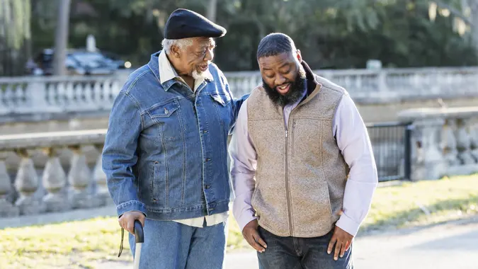 Senior African-American man and son at park, talking stock photo