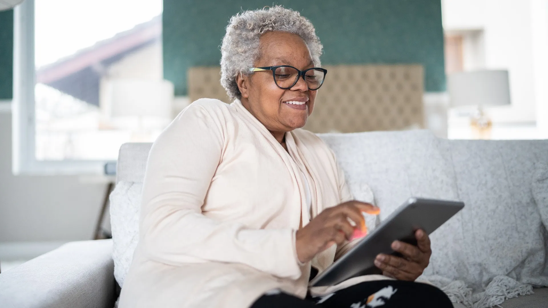 Senior woman using digital tablet at home stock photo