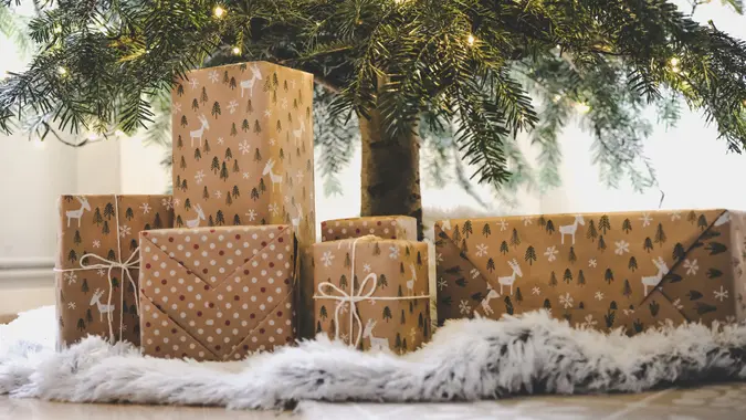 Beautifully wrapped presents under decorated tree.