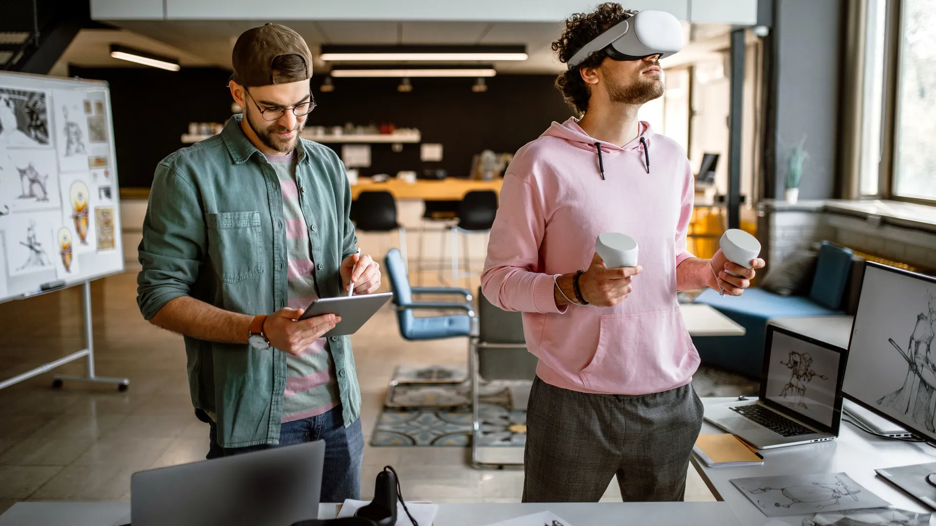 Group of colleagues in company office using virtual reality simulator headsets to test new video game they are creating.