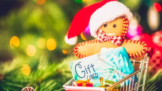 Shopping cart with gift card, Christmas gifts and gingerbread man.