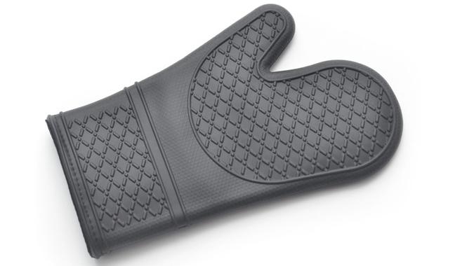 Closeup of a mass produced silicone oven mitt on a white background with shadows.