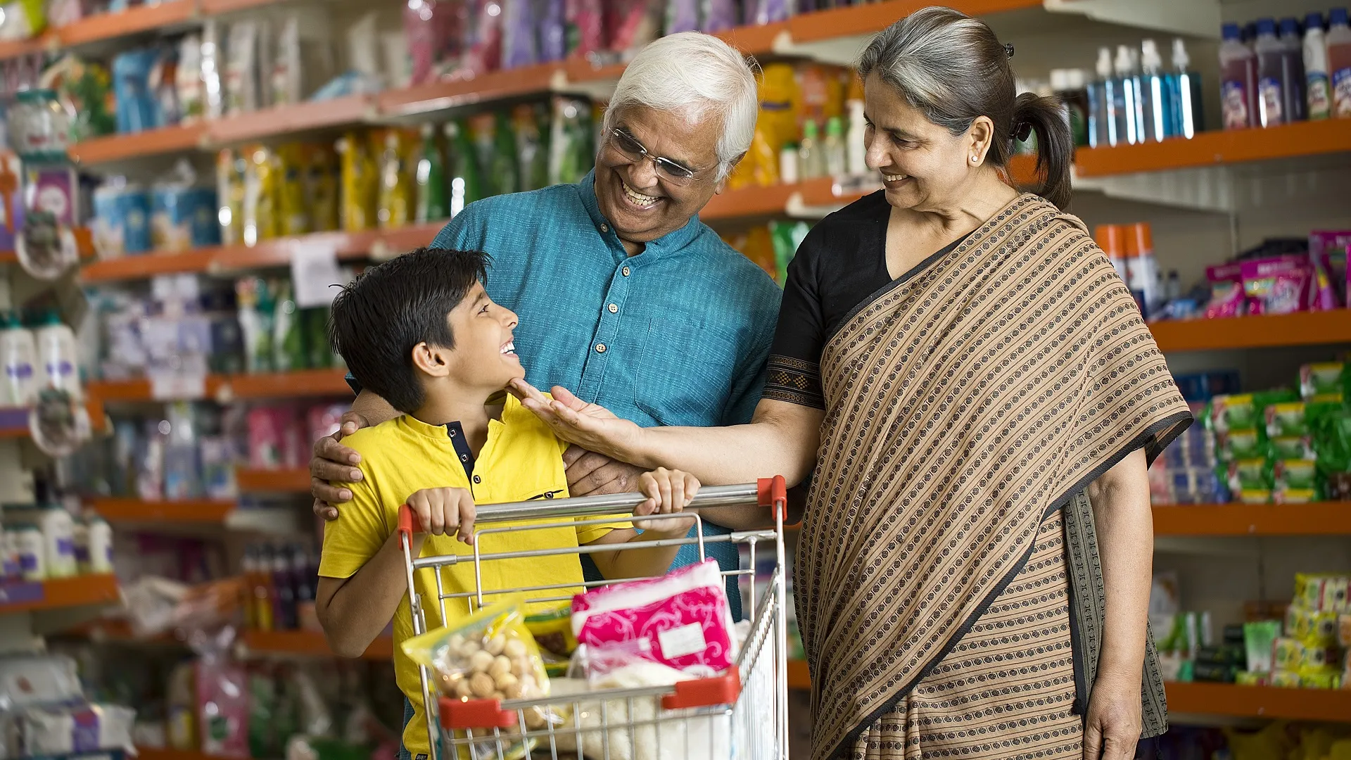 Grandparents with grandson shopping in supermarket stock photo