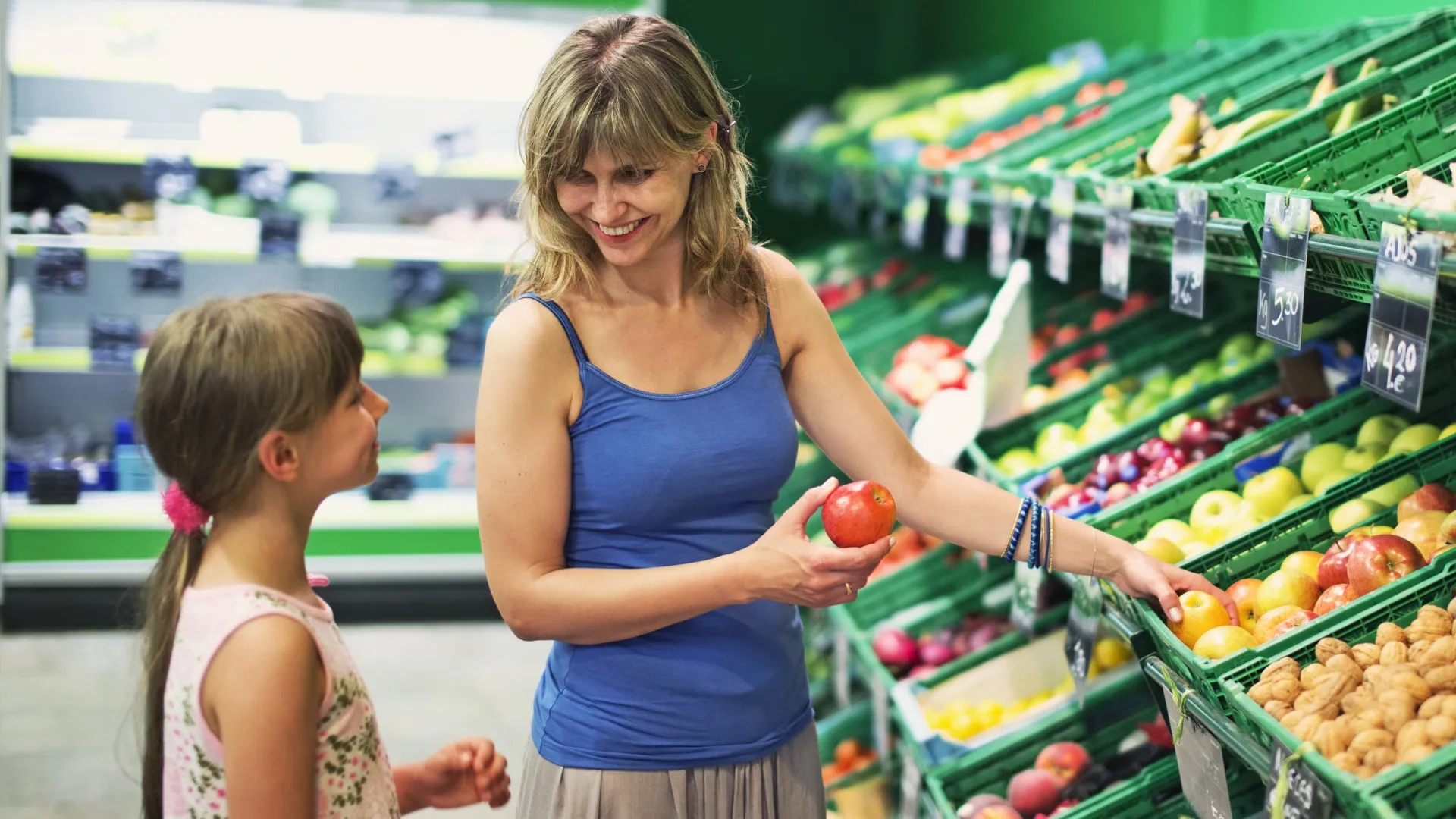 Mother and daughter buying groceries at a supermarket store stock photo