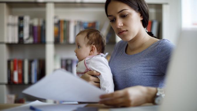 Young worried mother working from home stock photo
