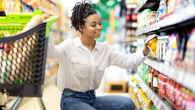 African Woman Choosing Products Doing Grocery Shopping In Supermarket stock photo