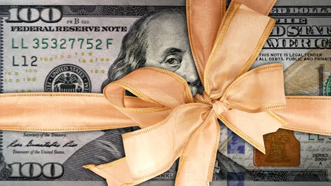 conceptual business and finance image of close up gift wrapped American one hundred dollar bill.